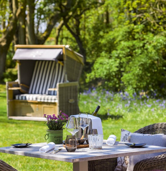 Strandkorb und gedeckter Tisch im Garten von Severins Resort & Spa Sylt