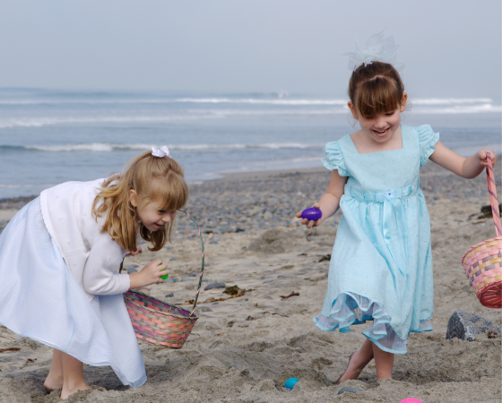 Zwei lachende Mädchen sammeln Ostereier am Strand vor dem Severin*s Resort & Spa auf Sylt.