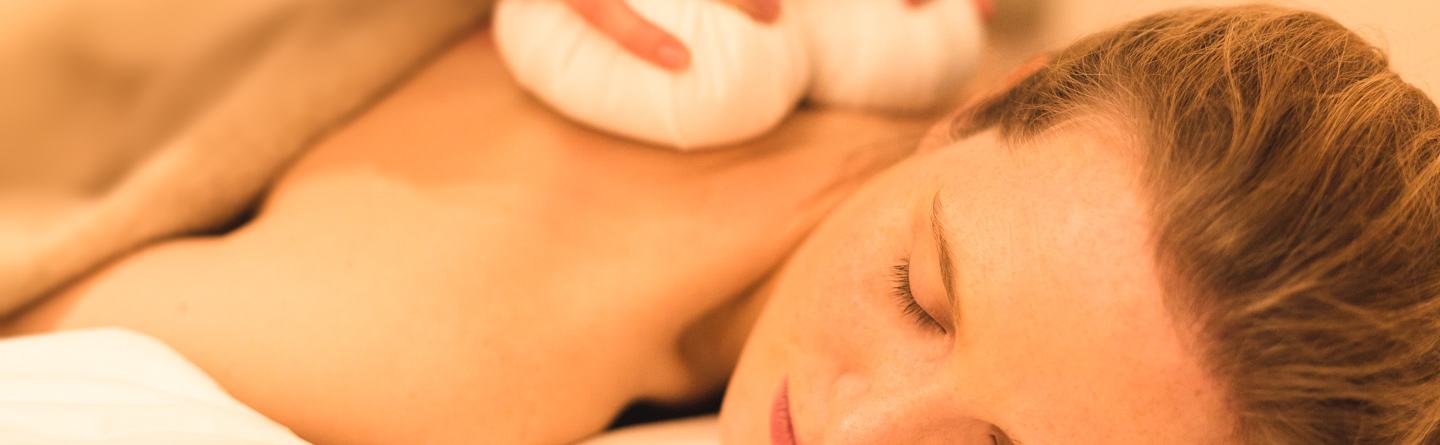 Woman during a stamp massage of the pampering program at the Severin*s Resort and Spa on Sylt