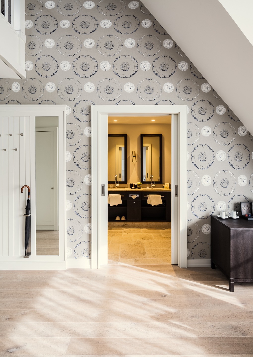 Elegantes Hotelzimmer mit stilvoller Tapete, Spiegel, Schiebetür zum Badezimmer und moderner Einrichtung.