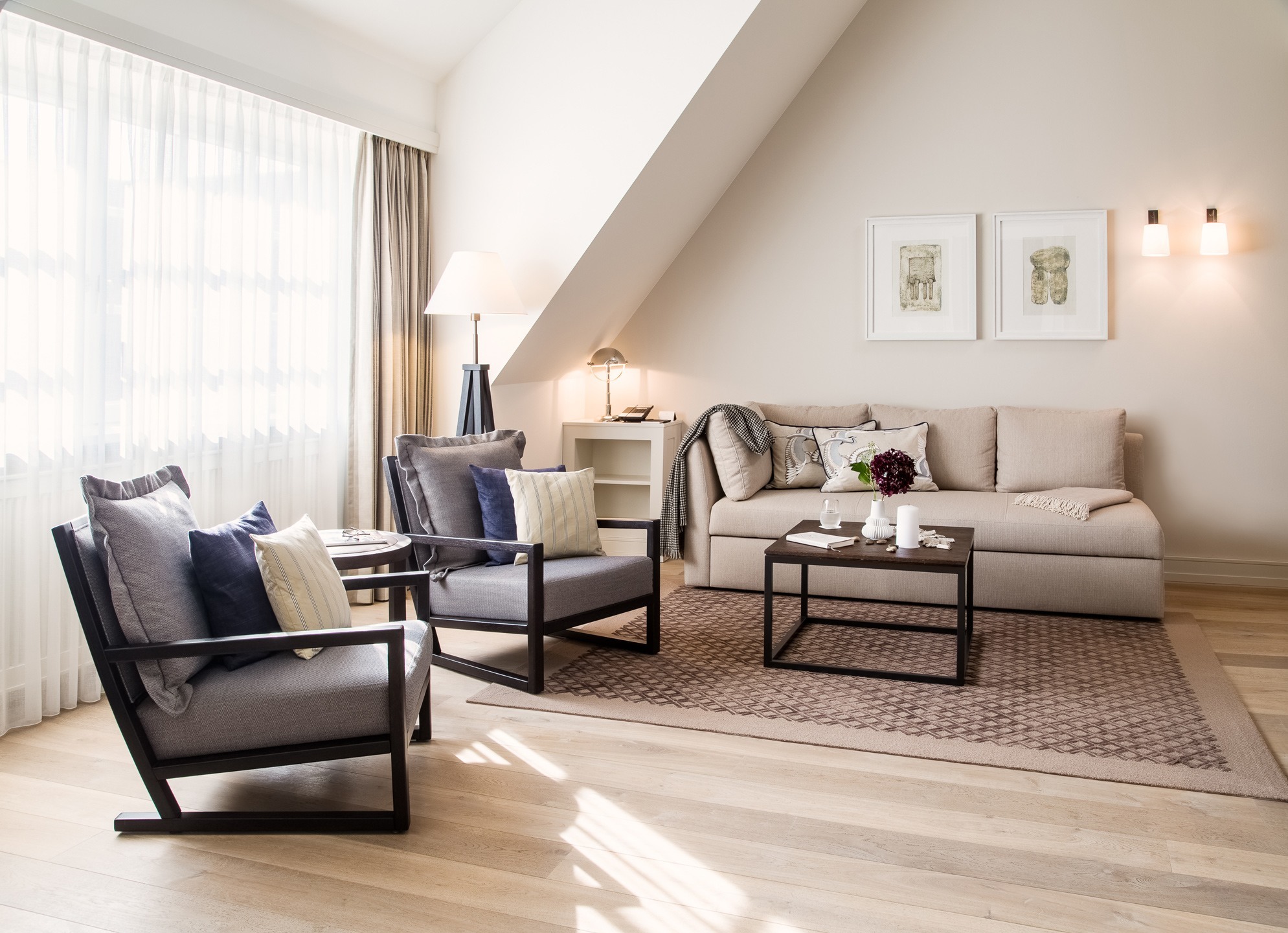 Elegantes Wohnzimmer im Severin*s Resort & Spa mit gemütlicher Couch, Sesseln, Tisch und stilvoller Dekoration.