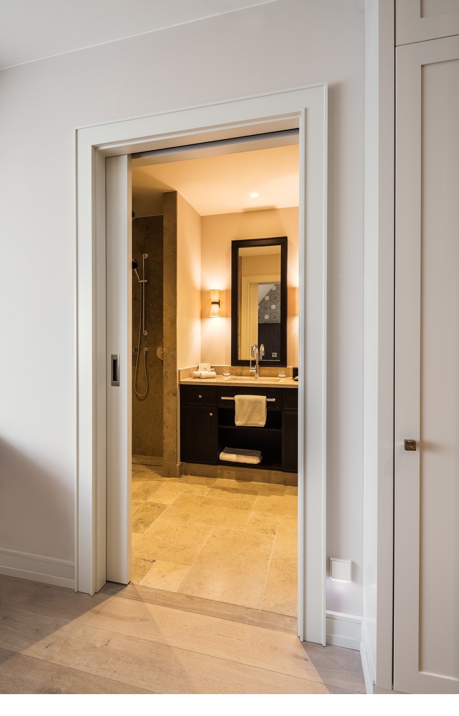 Modernes Badezimmer mit Spiegel, Waschtisch und Dusche im 5-Sterne-Hotel Severin*s Resort & Spa auf Sylt.