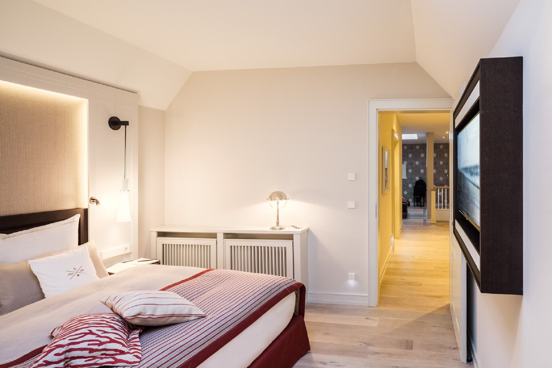 Elegantes Hotelzimmer mit gemütlichem Bett, stilvoller Beleuchtung und hellem Holzfußboden im Severin*s Resort & Spa.