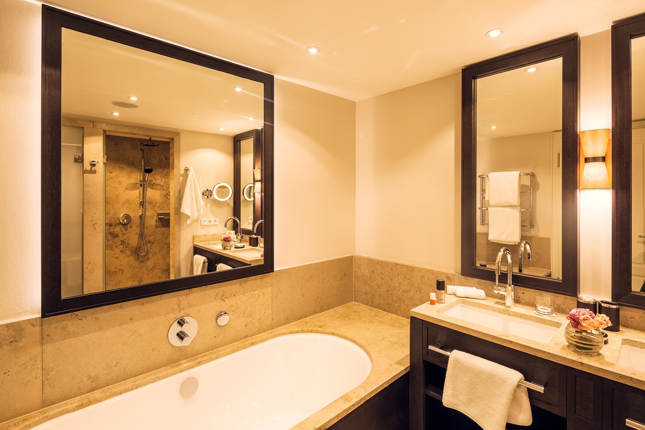 Luxurious bathroom with large bathtub, double washbasin, mirrors and elegant lighting at Severin*s Resort.