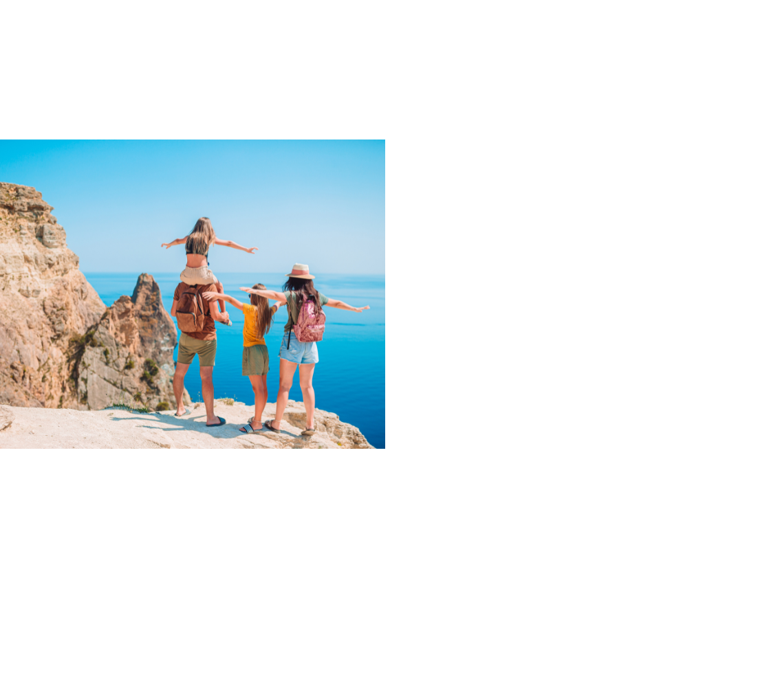 Familie genießt den Ausblick von einer Klippe mit Blick auf das blaue Meer unter klarem Himmel.