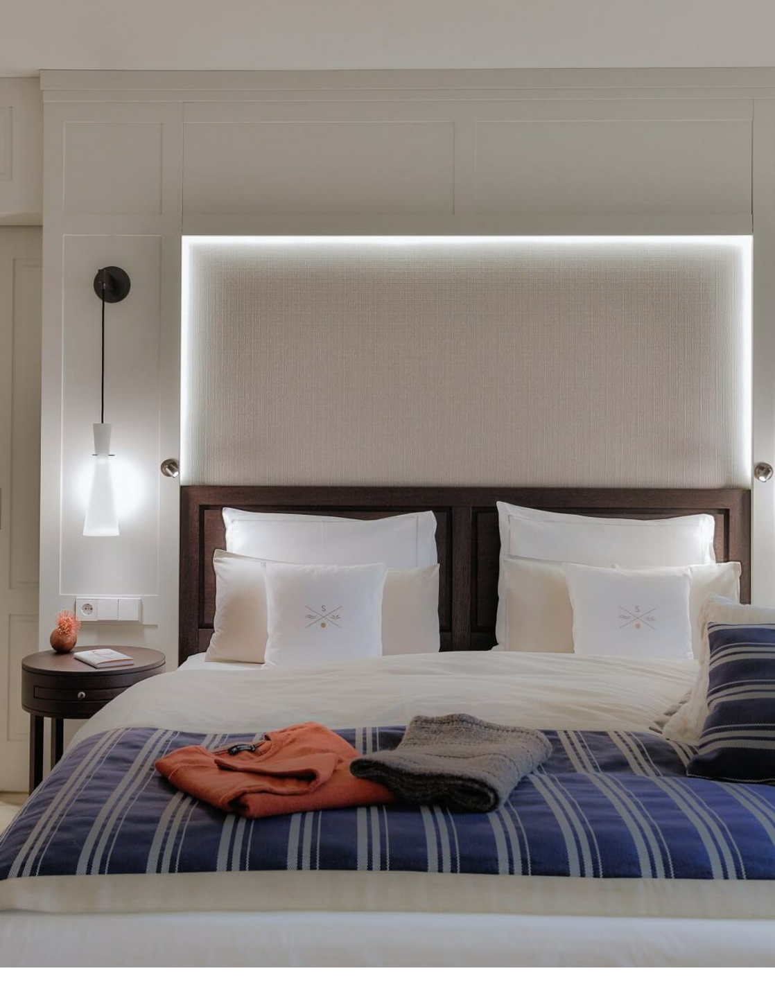 Elegant hotel room with a large bed, stylish lighting and a cozy atmosphere at Severin*s Resort & Spa on Sylt.