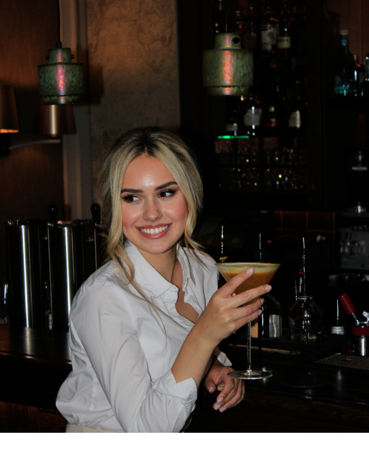 Person genießt Cocktail an stilvoller Hotelbar im Severin*s Resort & Spa auf Sylt.