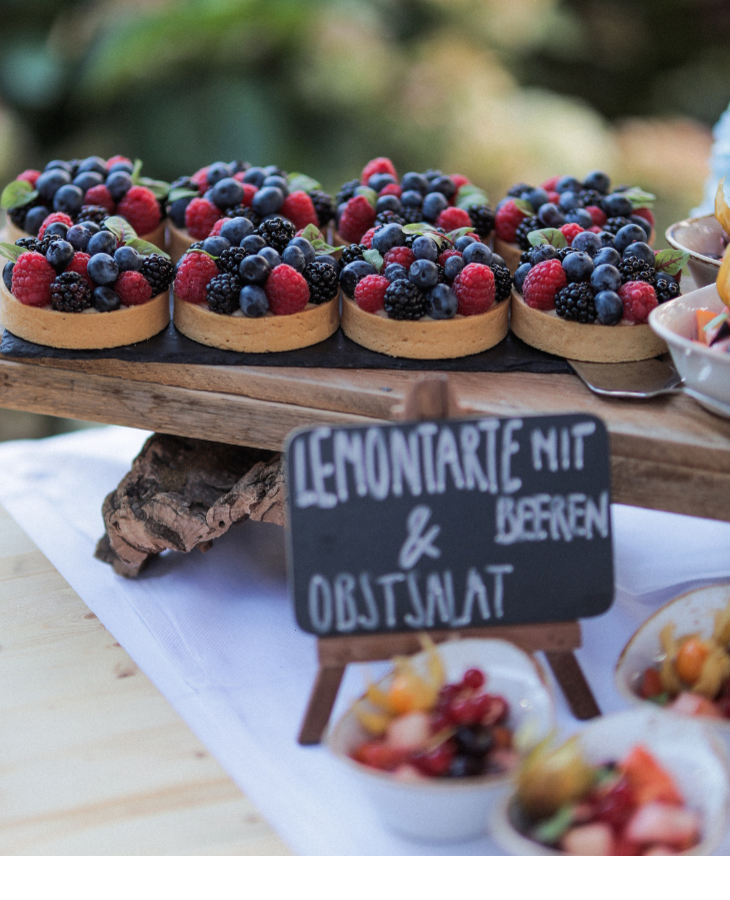 Frische Beerentörtchen und Obstsalat auf einem Holztablett im Severin*s Resort & Spa, Sylt.