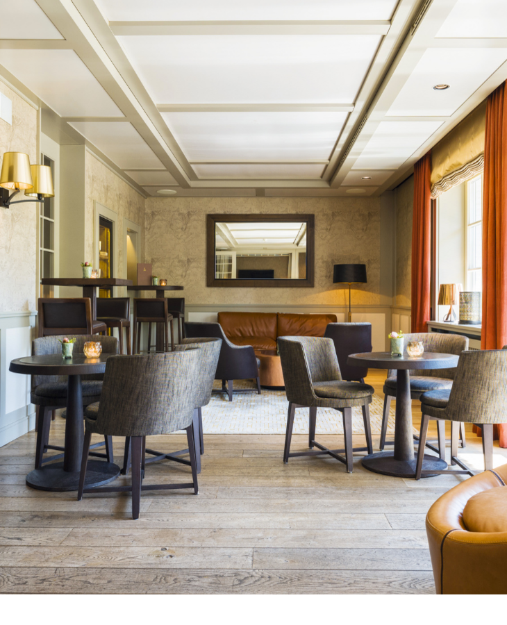 Eleganter Lounge-Bereich im Severin*s Resort & Spa mit modernen Sesseln, Holztischen und großen Fenstern.