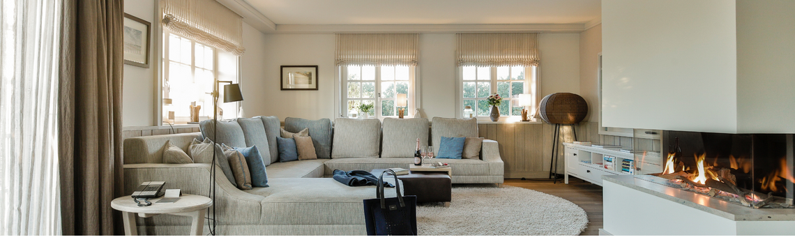 Elegant living room at Severin*s Resort with fireplace, large couch, wooden floor and stylish decoration.