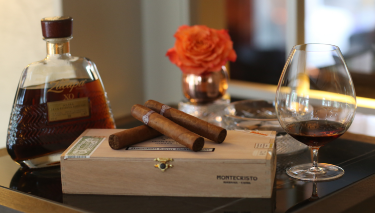 Edler Rum, Zigarren und eine Blume auf einem Tisch im Severin*s Resort & Spa, Sylt.