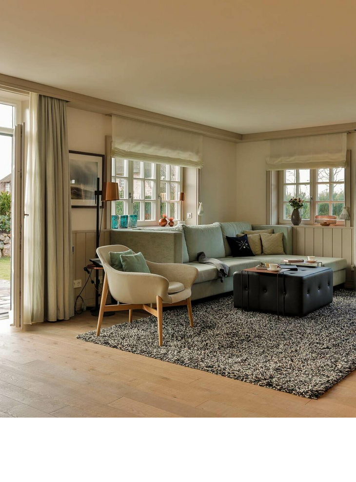 Living area & garden Bright living room at Severin*s Resort & Spa with sofa, armchairs, carpet and access to a garden.