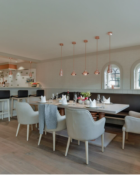 Elegant dining room with stylishly laid table, modern chairs and inviting bar at Severin*s Resort & Spa.