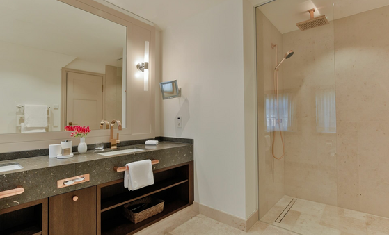 Modern bathroom at Severin*s Resort & Spa with large shower, double washbasin and elegant lighting.