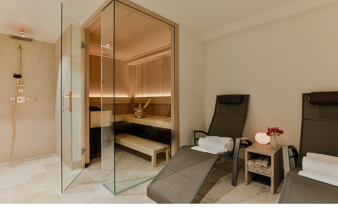 Private sauna with glass front, two loungers, towels and soft lighting at Severin*s Resort & Spa on Sylt.