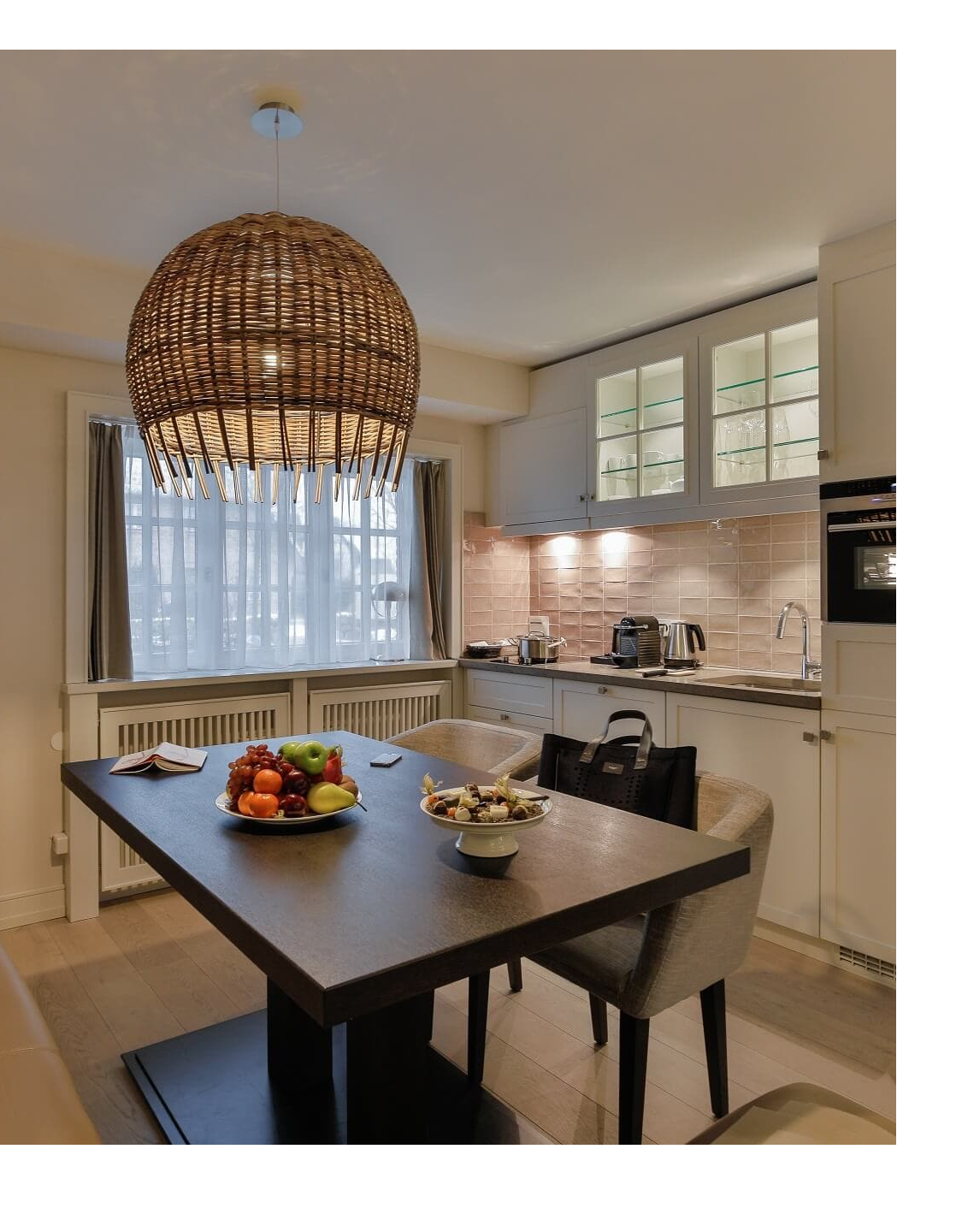 Cozy hotel kitchen with dining table, fruit bowl, modern furnishings and large hanging lamp at Severin*s Resort & Spa.