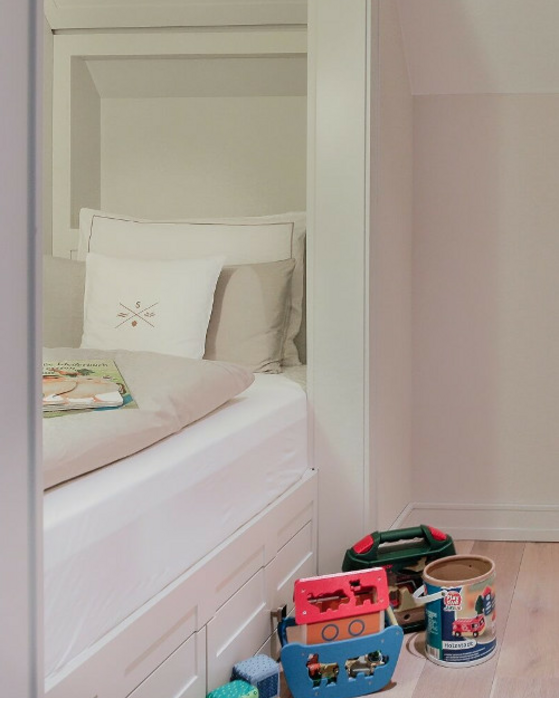 Helles Kinderzimmer im Severin*s Resort & Spa mit Spielzeug und gemütlichem Bett.