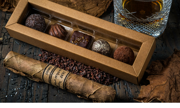 Severin*s Resort & Spa cigars and pralines Box of chocolates, cigar and glass of whiskey on a wooden table at Severin*s Resort & Spa, Sylt.