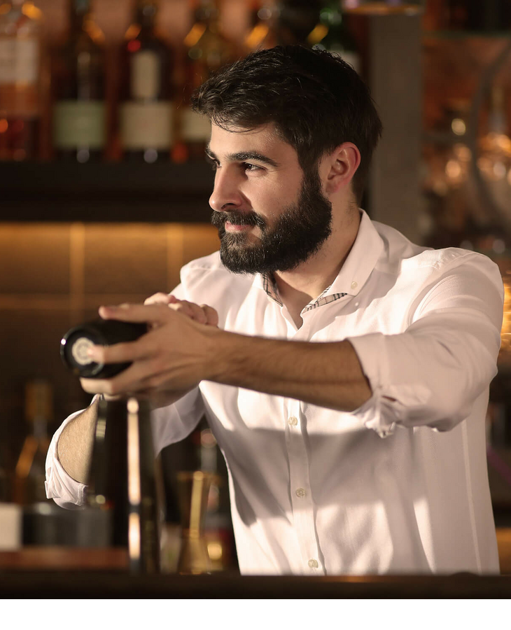 Bartender mixes a drink in the stylish bar of the Severin*s Resort & Spa, surrounded by fine spirits.