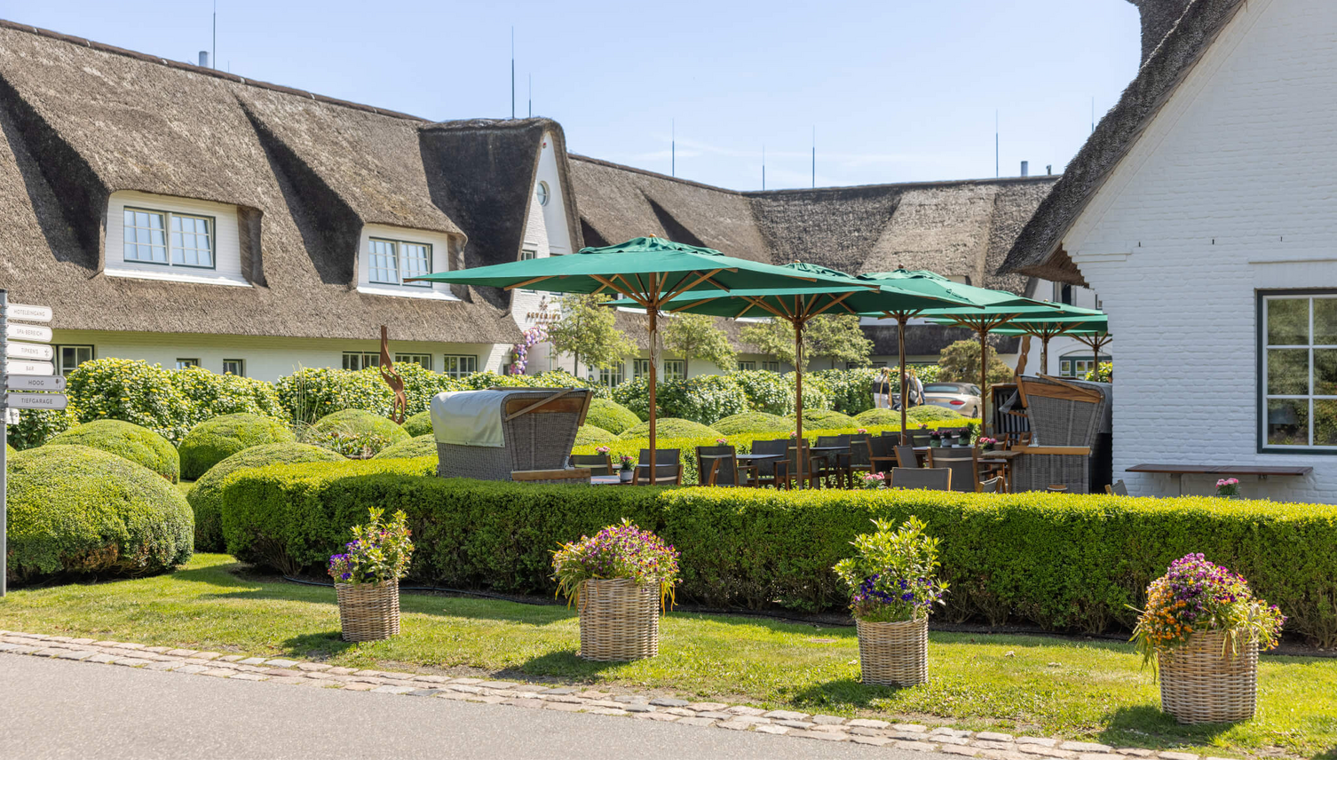 Terrasse mit grünen Schirmen vor dem Restaurant Hoog Sylt
