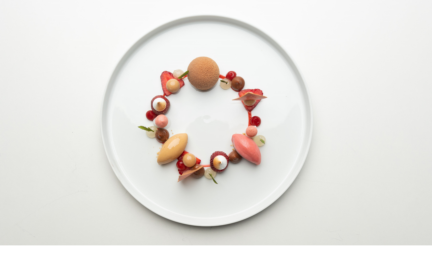 Dessert auf einem weißem Teller mit Erdbeeren und Schokolade