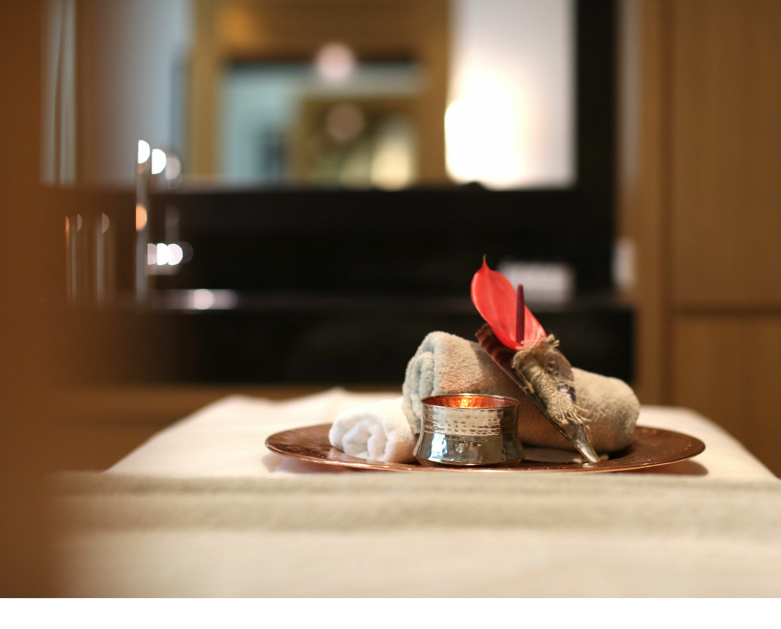 Wellness tray with candle, towel and red flower in the luxurious spa at Severin*s Resort & Spa on Sylt.