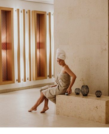 Woman in towel in the elegant spa area with modern wall accents at Severin*s Resort & Spa on Sylt.