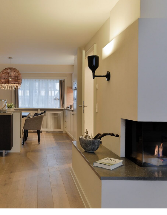 Elegant living room at Severin*s Resort & Spa, Sylt, with fireplace, dining table and modern furnishings.