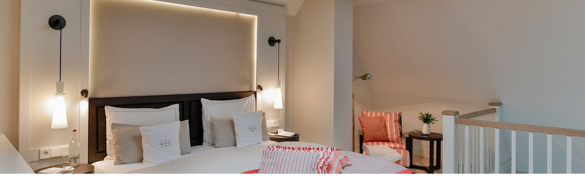 Modern hotel room with double bed, elegant lighting, cozy seating area and stylish decorations at Severin*s Resort.