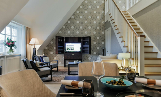 Elegant living room at Severin*s Resort with cozy seating area, dining table and stylish decoration.