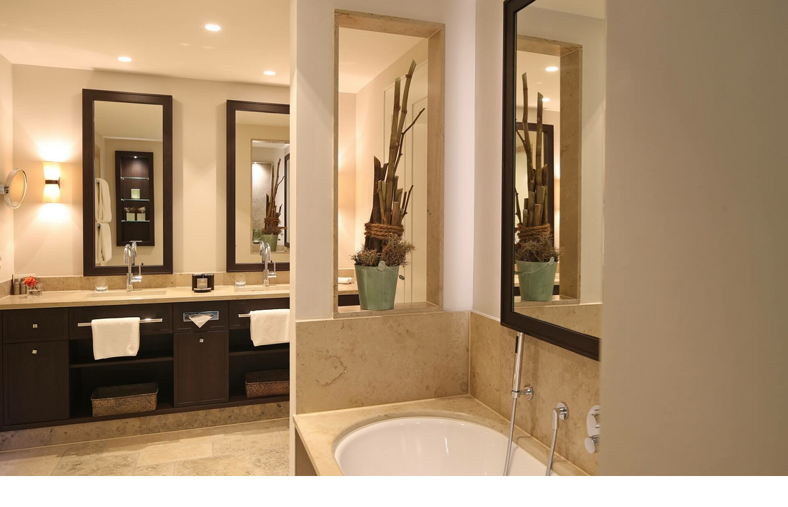 Luxuriöses Badezimmer im Severin*s Resort & Spa mit Doppelwaschbecken, Badewanne und stilvoller Dekoration.