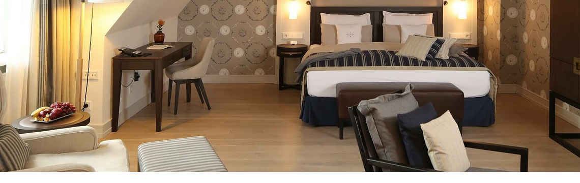 Luxurious hotel room with double bed, cozy sitting area, desk and stylish decoration at Severin*s Resort & Spa.