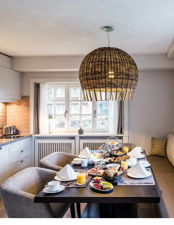Gemütliche Küche im Severin*s Hotel mit gedecktem Frühstückstisch und Blick aus großen Fenstern.