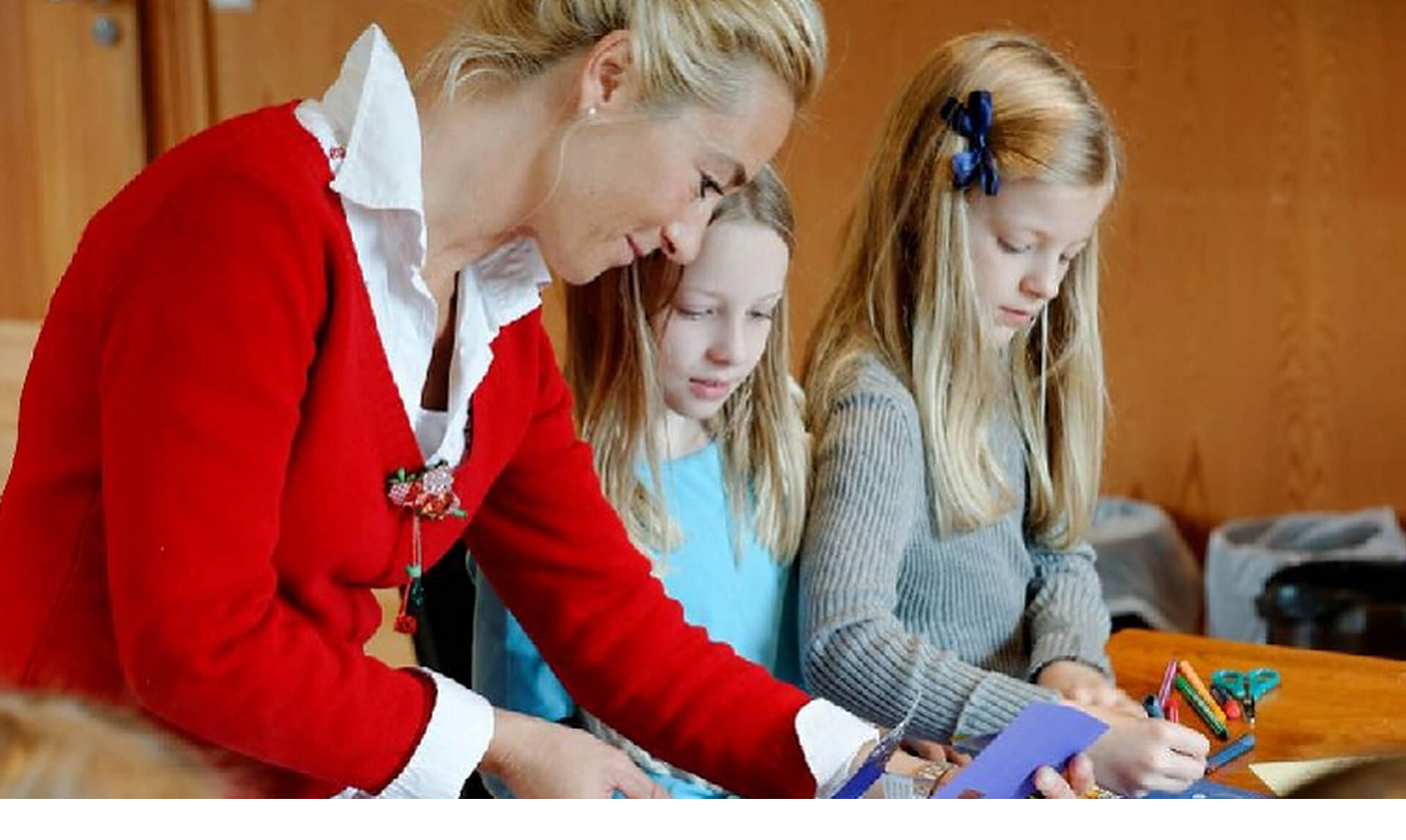 Eine Frau bastelt mit zwei Kindern an einem Tisch im Severin*s Resort & Spa auf Sylt.