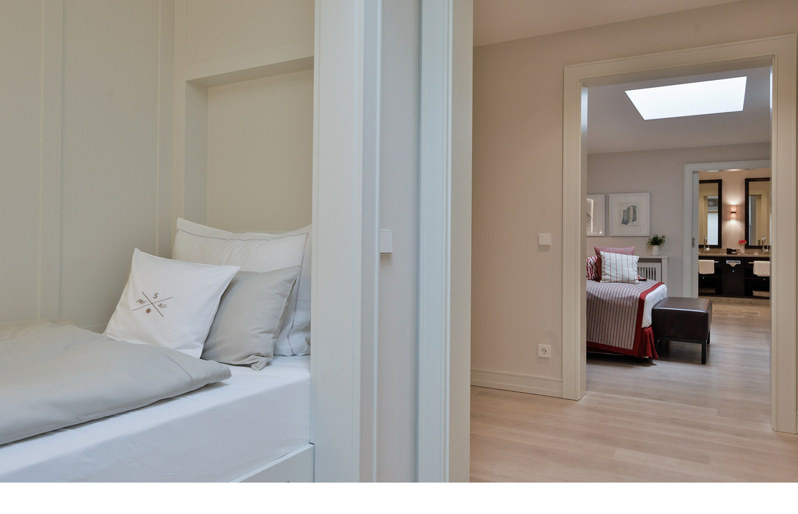 Elegant hotel room with modern design, comfortable bed and stylish bathroom at Severin*s Resort & Spa on Sylt.