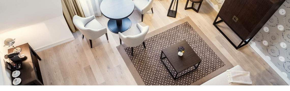 Helles, elegantes Wohnzimmer mit Sofa, Couchtisch, Teppich, Esstisch und Sesseln im Severin*s Resort & Spa auf Sylt.