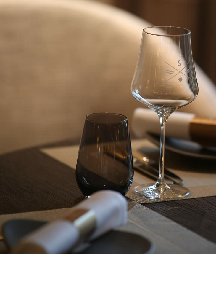 Eleganter, gedeckter Tisch im Severin*s Resort & Spa mit Weinglas, Stoffserviette und stilvoller Dekoration.