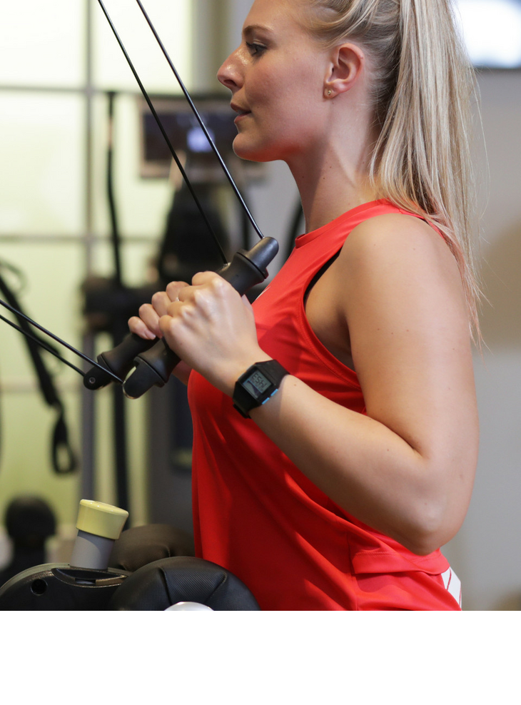 Personal Training im Severin*s Resort & Spa Sylt Frau trainiert im Fitnessstudio des Severin*s Resort & Spa auf Sylt, trägt rotes Sporttop.