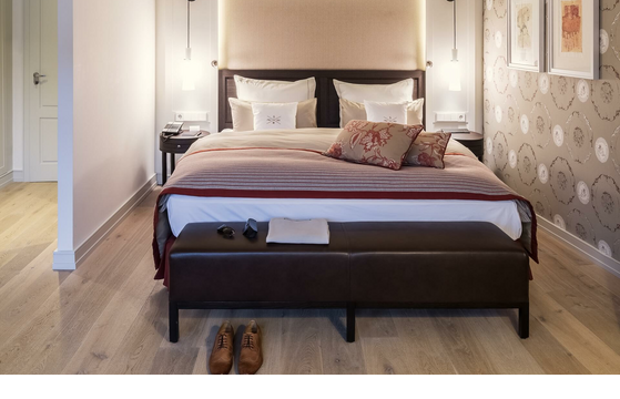 Luxurious hotel room with elegant double bed, stylish pillows, bedside tables and warm lighting at Severin*s Resort & Spa.