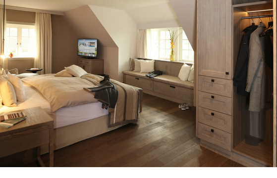 Elegantes Hotelzimmer mit Doppelbett, gemütlicher Sitzecke, Kleiderschrank und Flachbild-TV im Severin*s Resort & Spa.