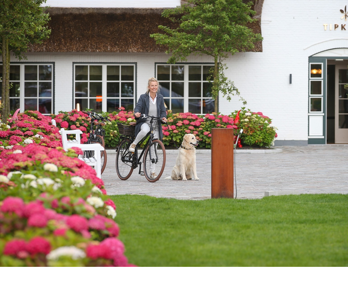 Gast mit Hund vor Hundedusche des Hotel Severin*s auf Sylt. Im Hintergrund der Eingang des Restaurants Tipken's