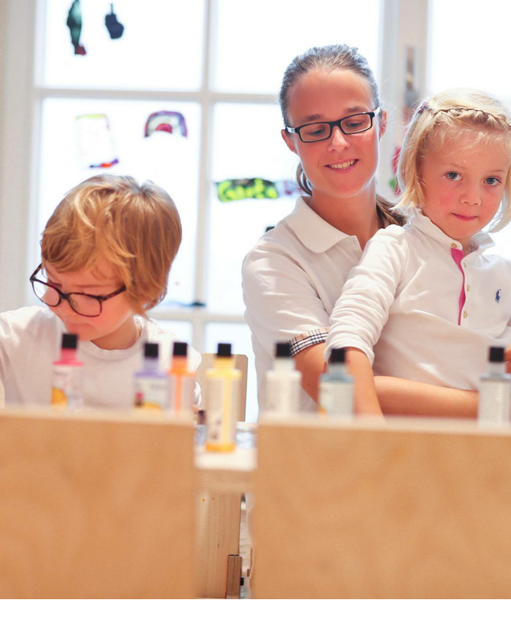 Betreuerin im Kids Club des Hotels Severin*s Sylt mit zwei spielenden Kindern Kinder basteln im Kids-Club des Severin*s Resort & Spa auf Sylt.