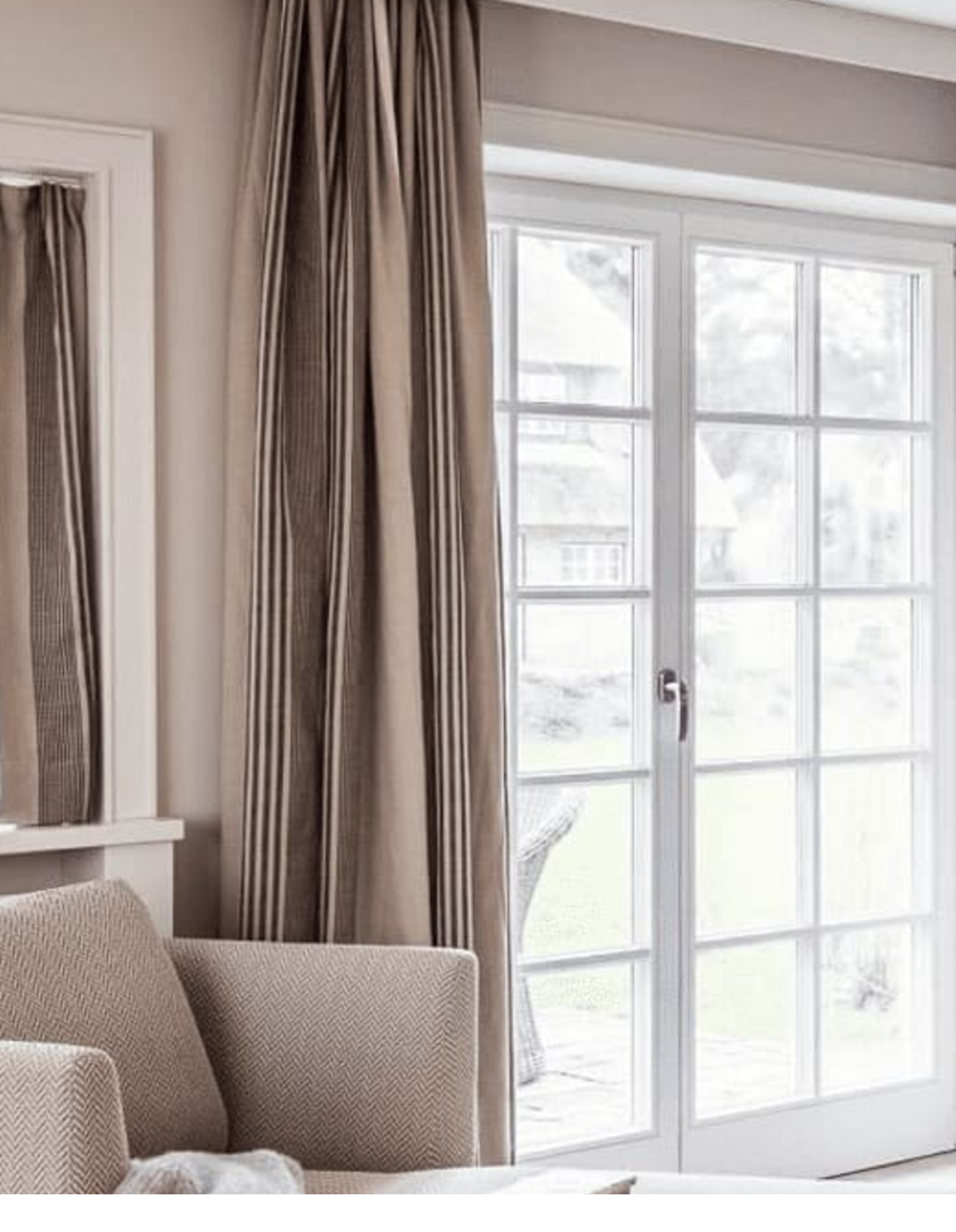 Elegantes Wohnzimmer mit beiger Chaiselongue, Decke und Büchern, vor großen Fenstern mit Vorhängen im Severin*s Resort.