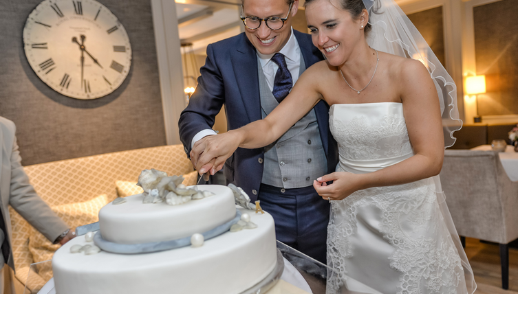 Brautpaar schneidet die Hochzeitstorte an im Sylter Restaurant Tipken's in der Guten Stube