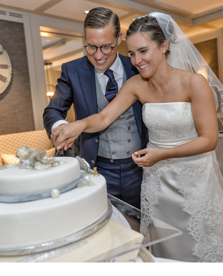 Bride and groom cutting the wedding cake at the elegant Hotel Severin*s Resort & Spa on Sylt.