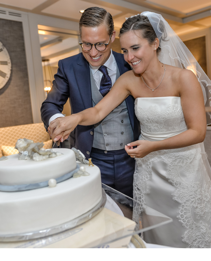Brautpaar schneidet die Hochzeitstorte an im Sylter Restaurant Tipken's in der Guten Stube