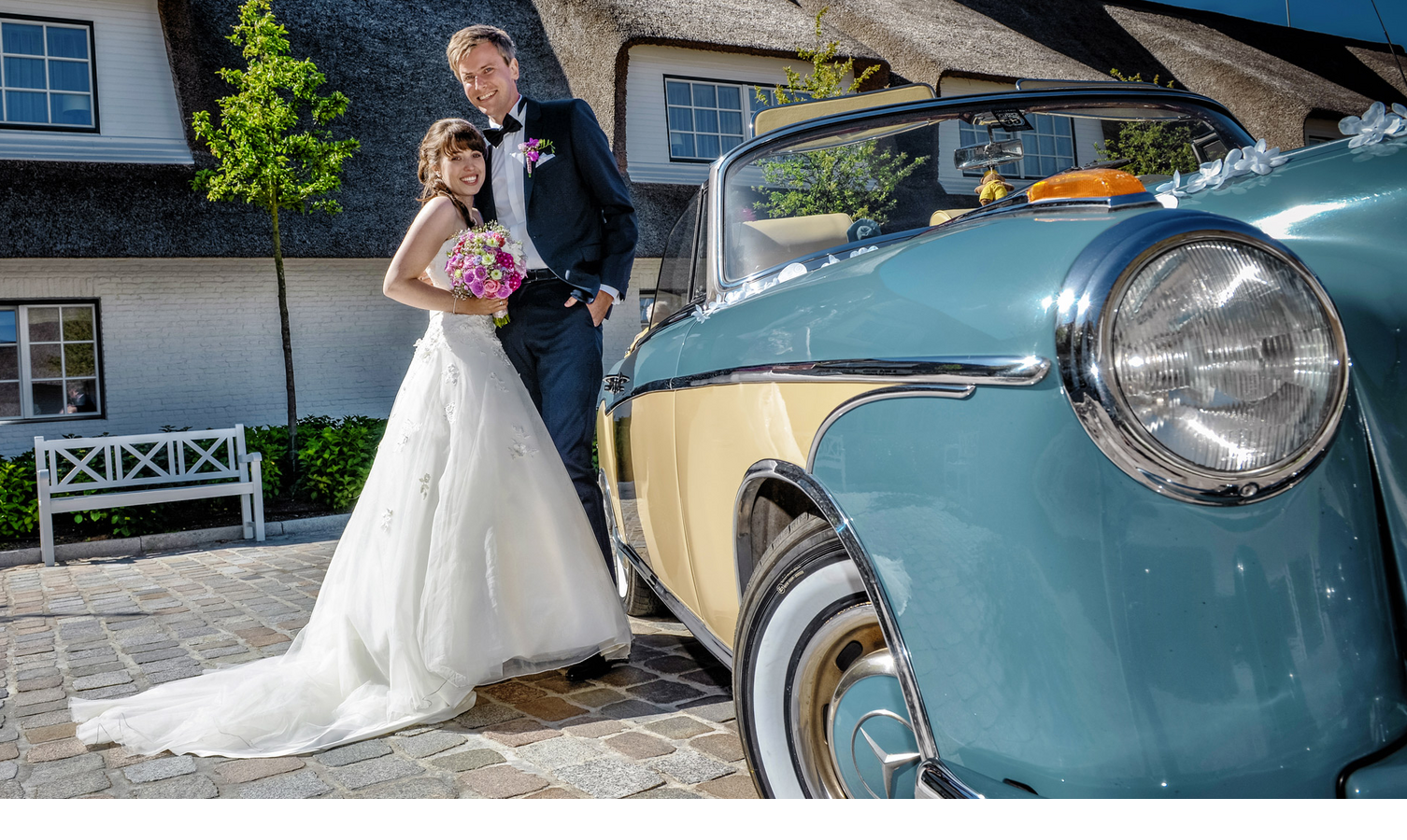 Bride and groom in front of a vintage car at Severin*s Resort & Spa on Sylt, bright sunshine.