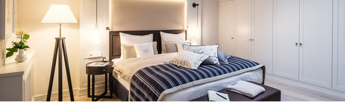 Elegantes Hotelzimmer mit Doppelbett, stilvoller Beleuchtung, Holzboden und moderner Einrichtung im Severin*s Resort & Spa.