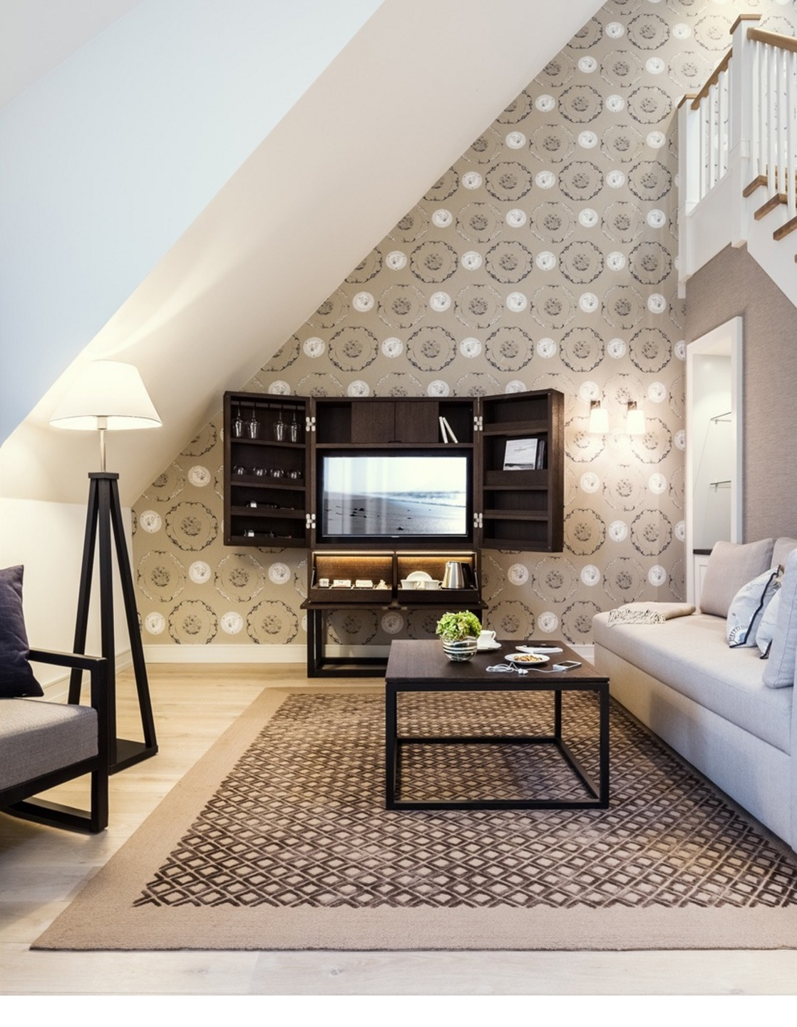 Cozy living room at Severin*s Resort with stylish furnishings, sofa, carpet, floor lamp and TV cabinet.