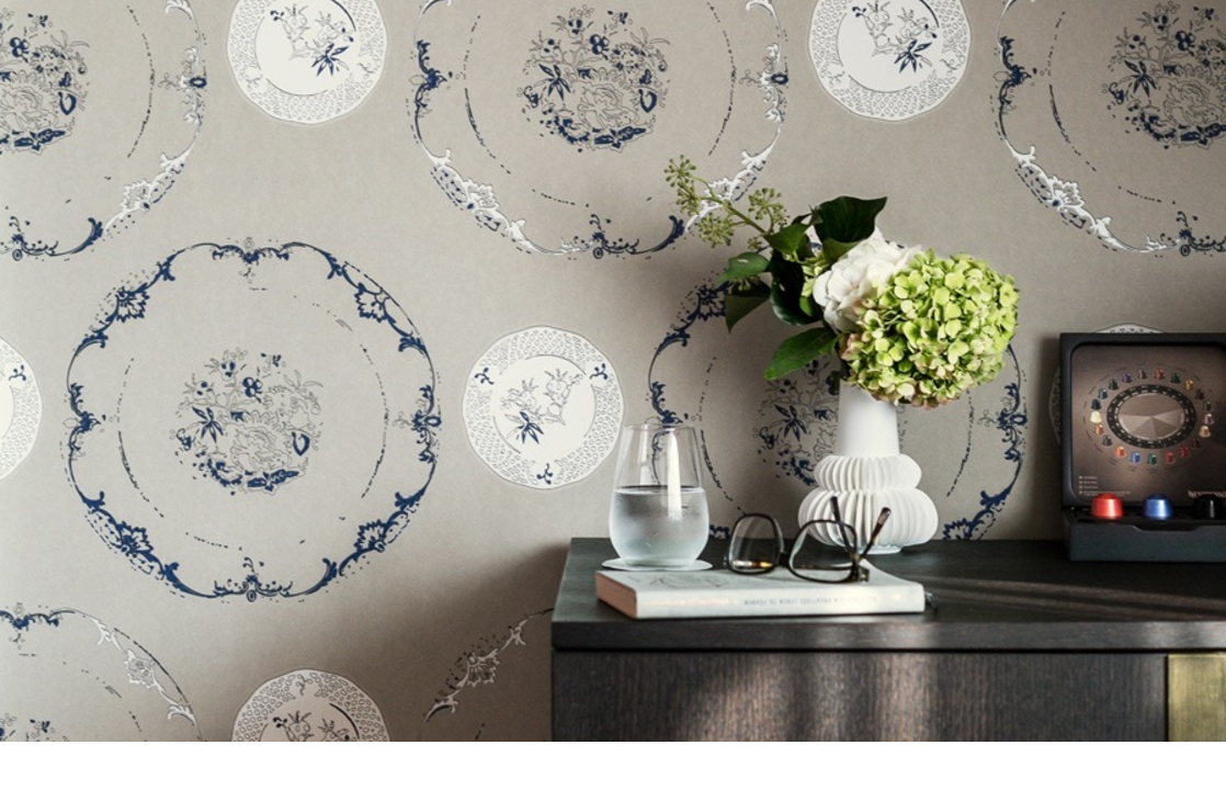 Decorative wallpaper with blue patterns, elegant vase with flowers on a dark table at Severin*s Resort & Spa.